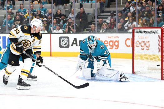 Brad Marchand (63) backhands a shot past Sharks goalie James Reimer to open the scoring