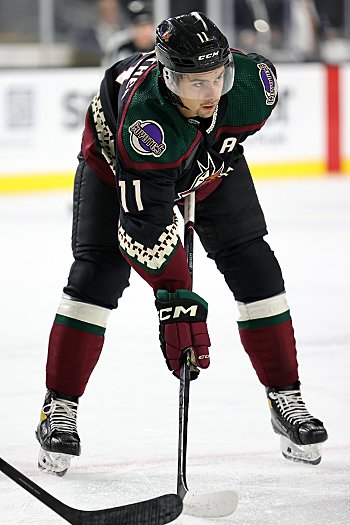 Dylan Guenther lines up for a faceoff