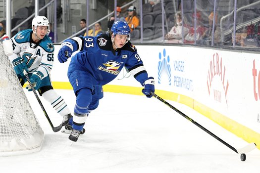 Jean-Luc Foudy (93) reaches for the puck as Derrick Pouliot (55) pursues