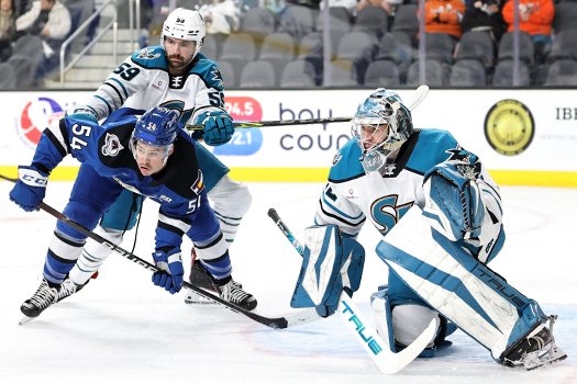 Nick Cicek (59) cross checks Charles Hudson (54) in front of goalie Eetu Makiniemi (32)