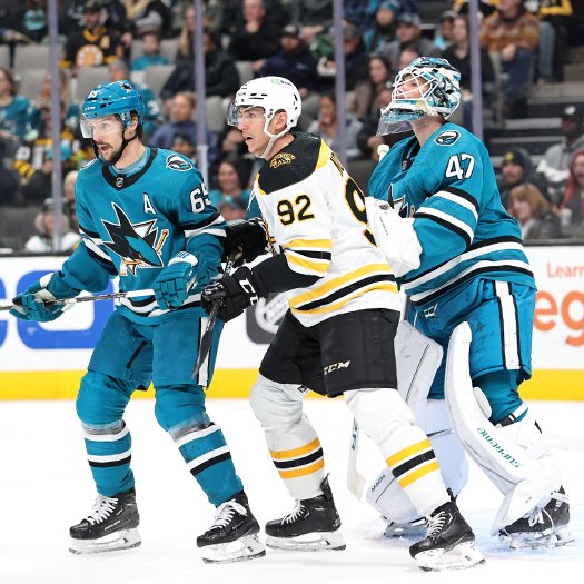 Sharks' goalie James Reimer attempts to look over Tomas Nosek (92) and Erik Karlsson (65) during a Bruins' first period power play
